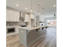 Modern kitchen with white cabinets, herringbone backsplash, and large island at 1976 Deco Dr, Kennesaw, GA 30144