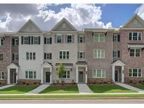 Charming townhome exteriors with brick and siding, complemented by well-maintained landscaping and inviting entryways at 1988 Deco Dr, Kennesaw, GA 30144