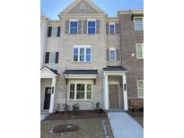 Three-story brick townhome with a front porch and landscaping at 1988 Deco Dr, Kennesaw, GA 30144