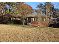 Charming single-story home featuring a brick facade and mature trees in a large, open front yard at 1417 Iris Lake Rd, Mcdonough, GA 30252