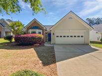 Charming single-Gathering home featuring a manicured lawn and a two-car garage at 424 Eglington Trl, Locust Grove, GA 30248