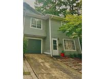 Green townhome exterior with driveway and landscaping at 1090 Brittwood Pl, Norcross, GA 30093