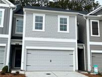 Charming two-story home with a gray exterior, garage, and well-maintained landscaping at 5142 Longview Run, Decatur, GA 30035