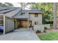 Charming home featuring a covered parking area, gray siding, and well-maintained landscaping at 882 Cedar Canyon Se Sq, Marietta, GA 30067