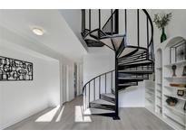 Stylish spiral staircase with grey carpeted steps and sleek black railing in a bright, white interior at 882 Cedar Canyon Se Sq, Marietta, GA 30067