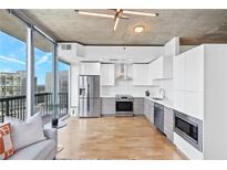 Modern kitchen featuring stainless steel appliances, white cabinetry, and a stunning city view at 3324 Peachtree Ne Rd # 2706, Atlanta, GA 30326