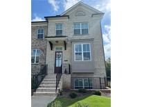 Beautiful townhome with brick facade, adorned with a welcoming wreath, and a well-maintained front yard at 4440 Sims Park Overlook, Suwanee, GA 30024