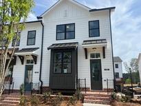 New construction townhome featuring a white facade, black window frames, and brick base at 630 Skytop Dr # 157, Cumming, GA 30040