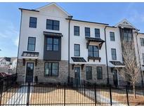 Townhome exterior features brick accents, black trim, and a white facade at 629 Silva St # 128, Cumming, GA 30040