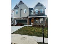 Two-story farmhouse-style home with gray siding, brick accents, and a large front yard at 4212 Adler Cir, Buford, GA 30519
