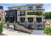 Modern condo building with brick facade and many windows, conveniently located near shops and restaurants at 8200 Main St # 1206, Woodstock, GA 30188