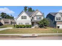 Two-story house with gray siding, stone accents, and a landscaped lawn at 2535 Grayton Loop, Villa Rica, GA 30180