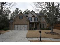 Charming two-story brick home with a manicured front yard and a two-car garage at 2170 Indian Ivey Ln, Dacula, GA 30019