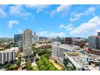 Expansive city view showcasing the skyline and treetops with a bright, sunny sky and puffy white clouds at 1065 Peachtree Ne St # 3003, Atlanta, GA 30309