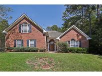 Brick house with a landscaped lawn and mature trees at 710 Stonehenge Pl, Jonesboro, GA 30236