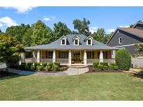 Craftsman style home with wrap-around porch and landscaped lawn at 216 Crescent Moon Way, Canton, GA 30114
