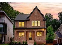 Stunning two-story brick home featuring large windows, manicured landscaping, and a classic, elegant design at 1277 Avalon Ne Pl, Atlanta, GA 30306