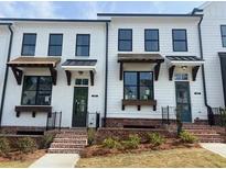 Charming two-story townhomes with brick accents and well-manicured lawns, offering a welcoming curb appeal at 628 Skytop Dr # 158, Cumming, GA 30040