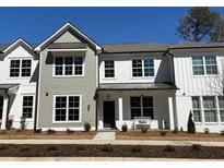 Charming townhome featuring gray and white exteriors, a cozy bench, and well-maintained landscaping at 689 Dobbs Rd, Woodstock, GA 30188