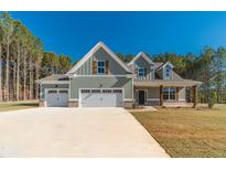 Two-story house with three-car garage and wood accents at 125 Pinewood Dr, Covington, GA 30014