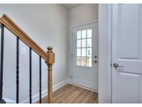 Welcoming entryway with wood-look floors and a glass paneled front door, complemented by an oak handrail and wrought iron balusters at 3405 Ripple Loop # 127, South Fulton, GA 30349