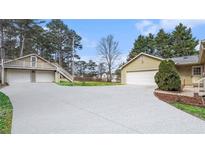 View of the home's exterior and detached garages; one with an upstairs balcony, the other attached to the home at 2601 Round Ridge Rd, Loganville, GA 30052