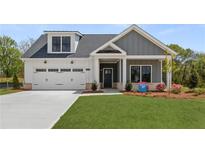 Charming home with a two-car garage, gray siding and a beautifully landscaped yard at 5210 Ginger Rose Ct, Cumming, GA 30028
