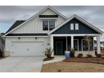 Charming two-tone home featuring white siding, a blue accent wall, and a welcoming front porch at 313 Sassafras Way, Holly Springs, GA 30115