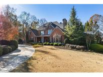 Stately brick home with manicured lawn and mature trees offering serene curb appeal at 13230 Addison Rd, Roswell, GA 30075