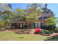 Charming two-story brick home with manicured lawn and flowering trees, offering classic curb appeal at 2921 Wickford Nw Dr, Kennesaw, GA 30152