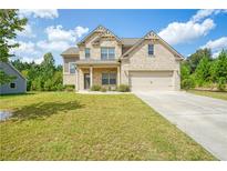 Charming two-story home featuring brick facade, well-manicured lawn, and an attached two-car garage at 3201 Camden Ct, Atlanta, GA 30349