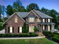 Charming two-story brick home with landscaped yard and covered porch, offering classic curb appeal and an inviting entrance at 719 Settlers Xing, Canton, GA 30114