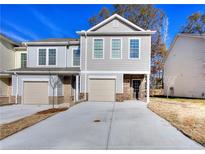 Charming townhome with a one-car garage and long driveway, complemented by a well-maintained lawn at 6214 Ripple Way # 91, South Fulton, GA 30349