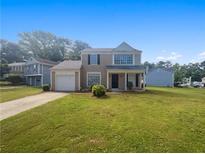 Charming two-story home with a well-maintained lawn and attached single-car garage at 6235 Marbut Farms Trl, Lithonia, GA 30058