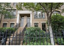 Brick front exterior of townhome with steps leading to the entrance and a black metal fence at 37 Honour Nw Ave, Atlanta, GA 30305