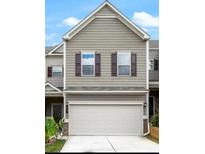 Tan two-story townhome with white garage door and dark brown shutters at 21 Crescent Chase Dr, Dallas, GA 30157