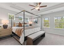 This bedroom features a four-poster bed, tray ceiling, and lots of natural light at 3136 Washburn Se St, Atlanta, GA 30354