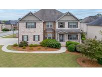 Two-story brick home with landscaped lawn and walkway at 3172 Trinity Grove Dr, Dacula, GA 30019