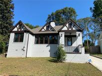 Renovated white brick home with dark brown accents and a landscaped lawn at 1677 S Gordon Sw St, Atlanta, GA 30310