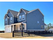 Beautiful two-story home featuring navy siding, white brick accents, and a charming covered porch at 738 Crossroad Ct, Powder Springs, GA 30127