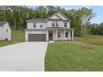 Charming two-story home with a two-car garage, manicured lawn, and inviting front porch at 404 Beacon Way, Villa Rica, GA 30180
