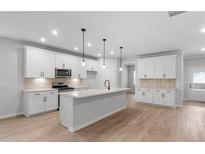 Bright kitchen features white cabinets, stainless appliances, and a stylish island, perfect for modern living at 404 Beacon Way, Villa Rica, GA 30180