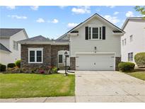Charming two-story home with a stone accent wall, lush green lawn, and a two-car attached garage at 6329 Edgewater Cv, Fairburn, GA 30213