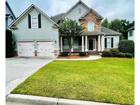Charming two-story home featuring stone accents and a well-manicured lawn at 306 Mountain Laurel Walk, Canton, GA 30114