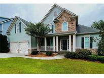 Charming two-story home with stone accents, a covered porch, and a well-manicured lawn at 306 Mountain Laurel Walk, Canton, GA 30114