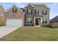 Two-story brick home with a well-maintained front yard and attached two-car garage at 916 Dexter Dr, Stockbridge, GA 30281