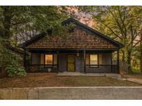 Charming bungalow-style home featuring a welcoming front porch, unique wood shingles, and a landscaped front yard at 904 Smith Sw St, Atlanta, GA 30310