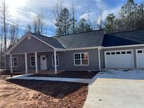 Charming single story home with a covered entryway and a spacious three car garage at 1250 Adamson Rd, Bowdon, GA 30108