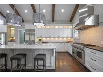 Bright kitchen features white cabinets, marble counters, a stainless hood, dark floors and wood beam details at 2908 Mabry Ne Ln, Brookhaven, GA 30319