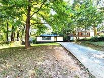 Well-maintained single-story home with a long driveway nestled among mature trees at 2924 Sylvan Rd, East Point, GA 30344